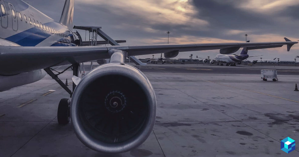 Picture of a commercial passenger plane jet and wing while it is parked on tarmac. Learn more about the component needs in civil aviation and see how Sourcengine can help you procure them.