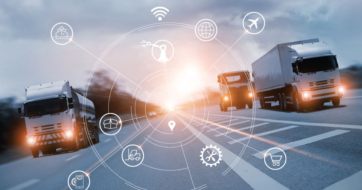 Cargo trucks driving with the sunset in the backdrop as the deliver component supplies to manufacturing companies; find out why supply chain professionals must digitize the chain now in 2020.