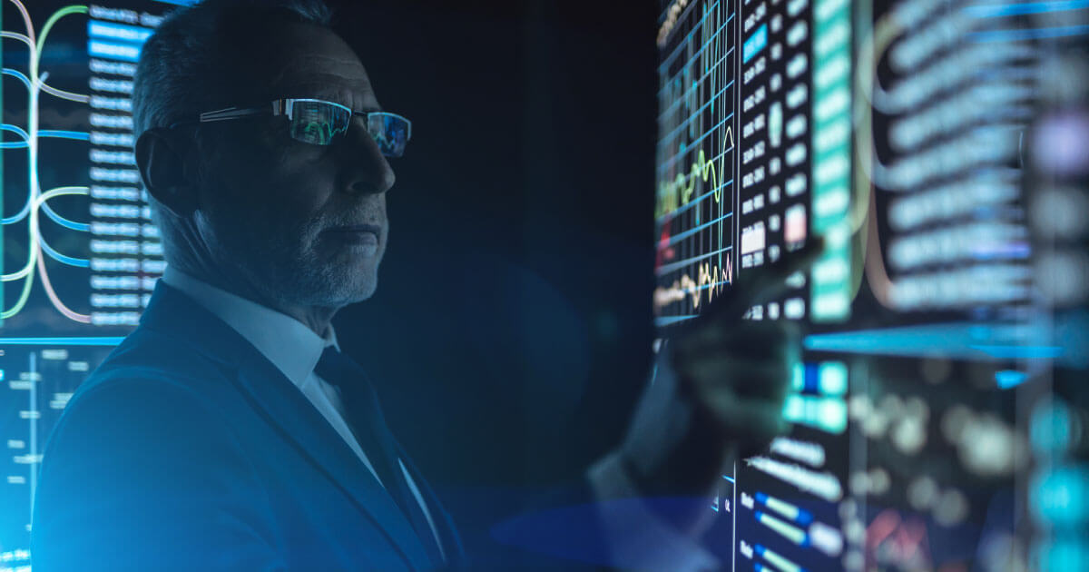 A CEO oversees a computerized board display telling him vital information about his company's supply chain; find out why CEOs must digitize the supply chain in 2020