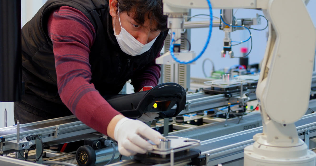 A design engineer wearing MRO equipment (maintenance, repair, and operations) while he words on a circuit inside the lab; find out more on acquiring MRO/PPE equipment at Sourcengine.