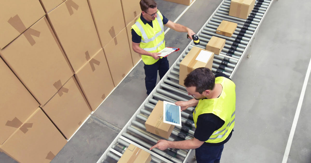 Two supply chain specialists using tablet computers while checking components. See how your supply chain can be made more agile with technology platforms like Sourcengine.