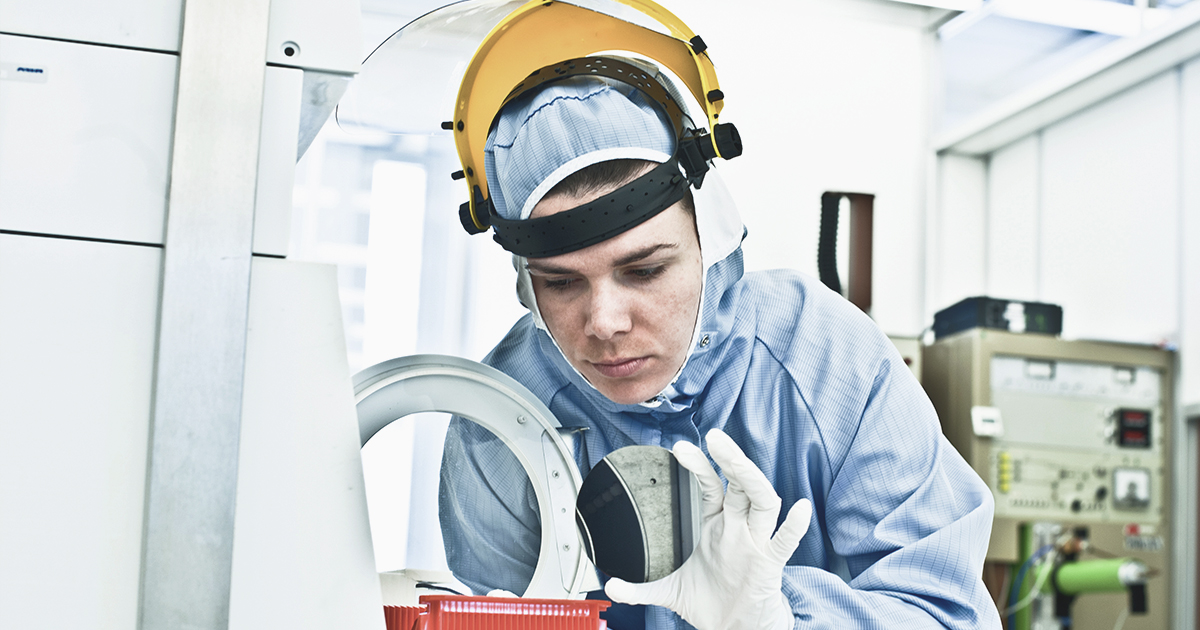 An engineer examines a silicon wafer in a chip factory clean room | Sourcengine