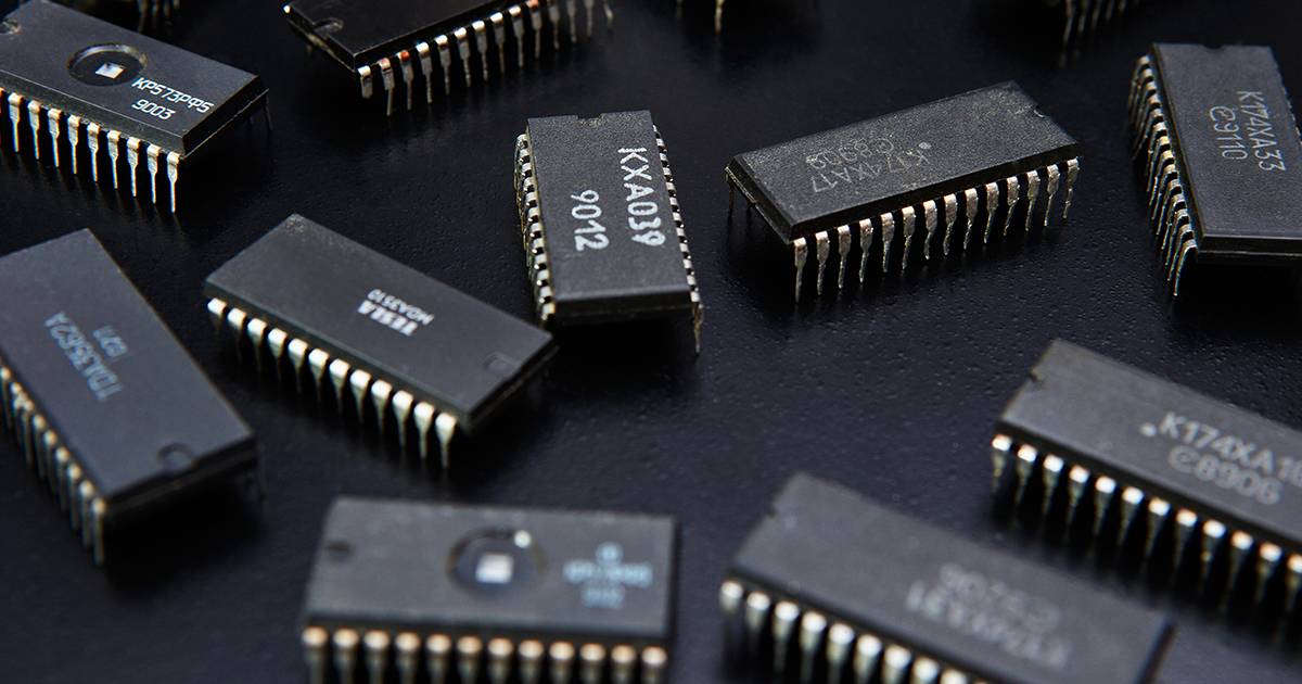 Eleven mature node microchips scattered in front of a black background.