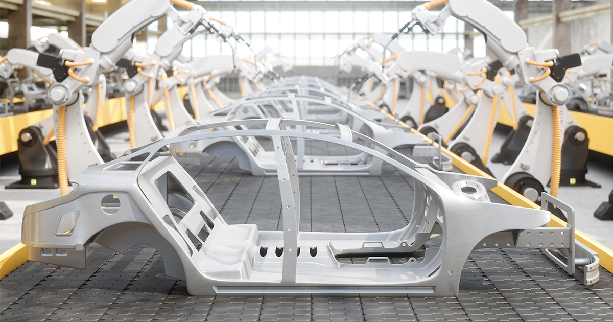 A long line of automobile chassis moving through two rows of smart automobile assembly robots.