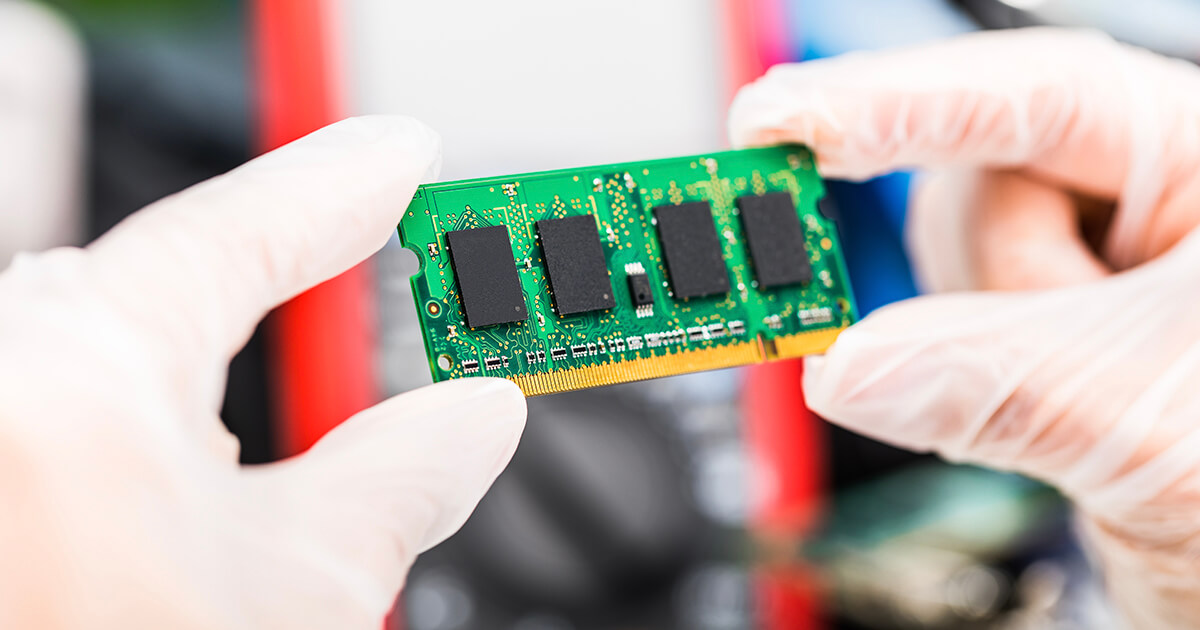 A pair of gloved hands holds a laptop DRAM module. | Sourcengine