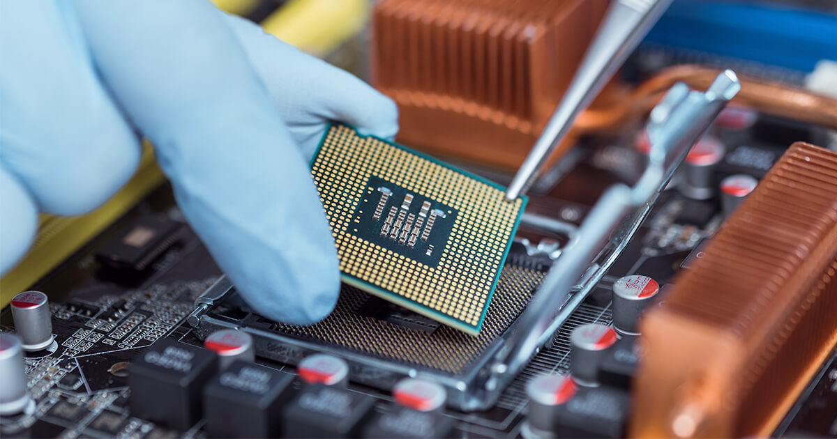 A gloved engineer places a processor into a fully assembled laptop PCB. | Sourcengine