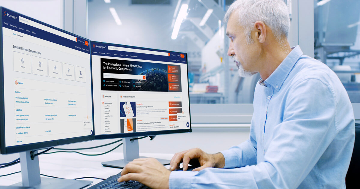 A man seated at a desk in an office environment looks at the Sourcengine homepage on his computer display. 