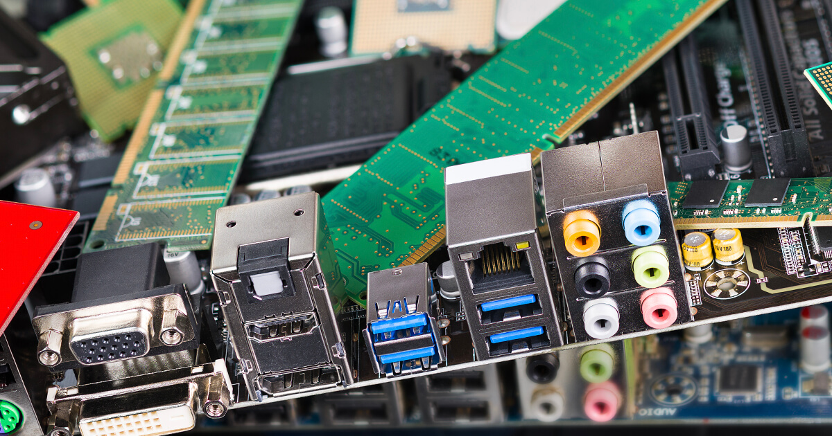 A pile of PCBs, topped by a board featuring VGA, HDMI, USB, RJ-45, and computer audio port connectors.