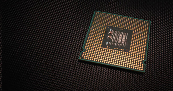 A single CPU sits on a mat in a darkened area.