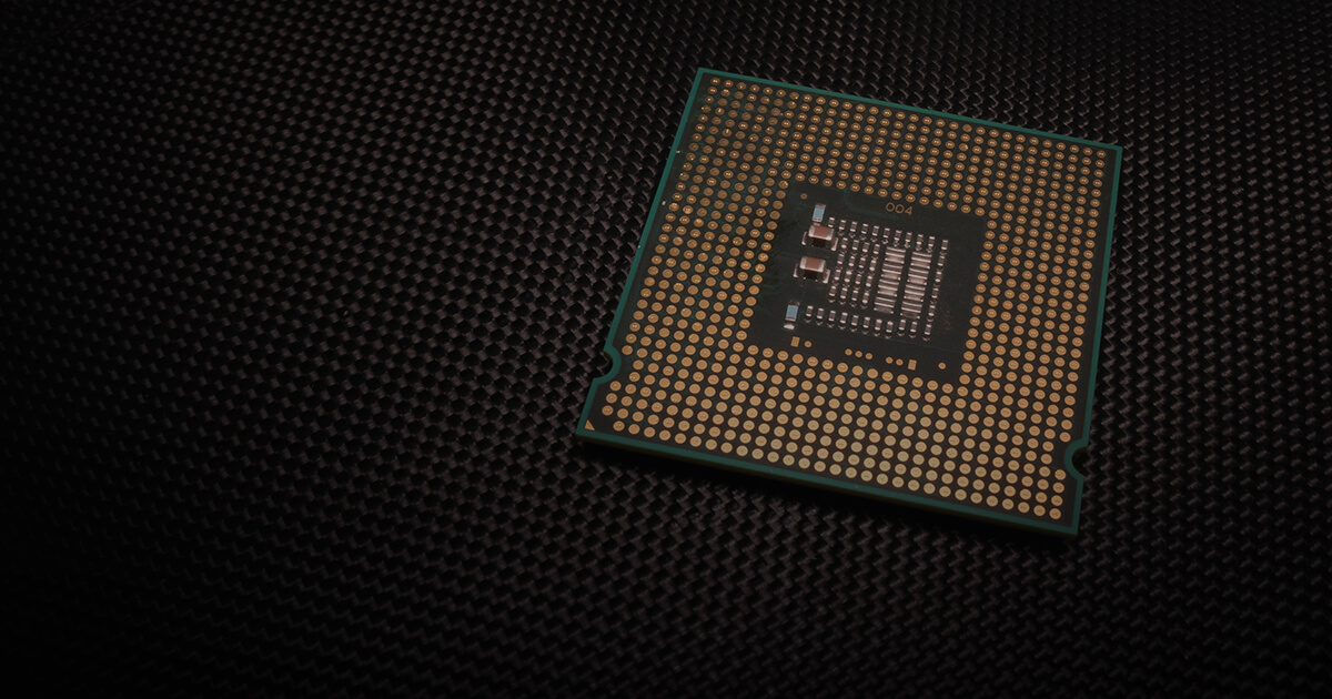 A single CPU sits on a mat in a darkened area.