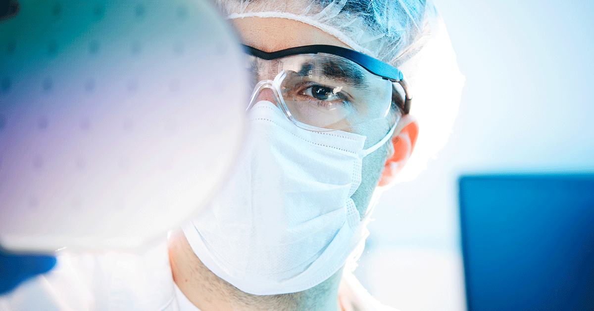 man examining something while wearing a mask