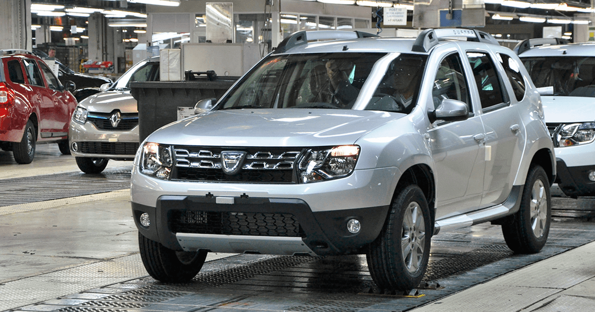 Three brand new SUVs sit in a car factory during the manufacturing process