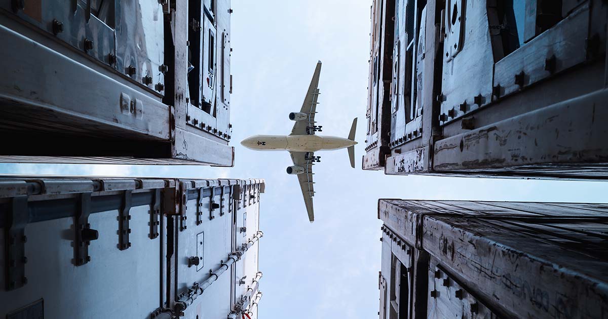 Plane flying overhead between buildings