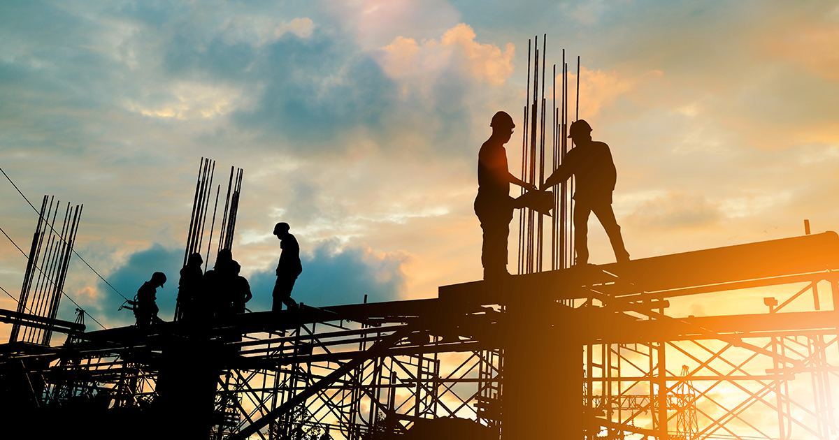 Construction workers in shadow at sunset