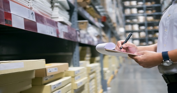 An auditor examining stock in a warehouse 