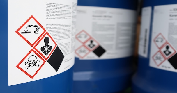 A close-up on the warnings for a chemical storage barrel