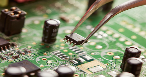 Close up image of someone placing a chip on a circuit board